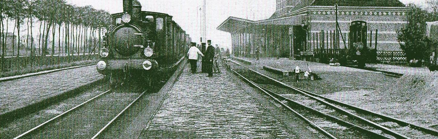zwartwit foto van het station in Tiel met een stoomtrein en mensen ernaast