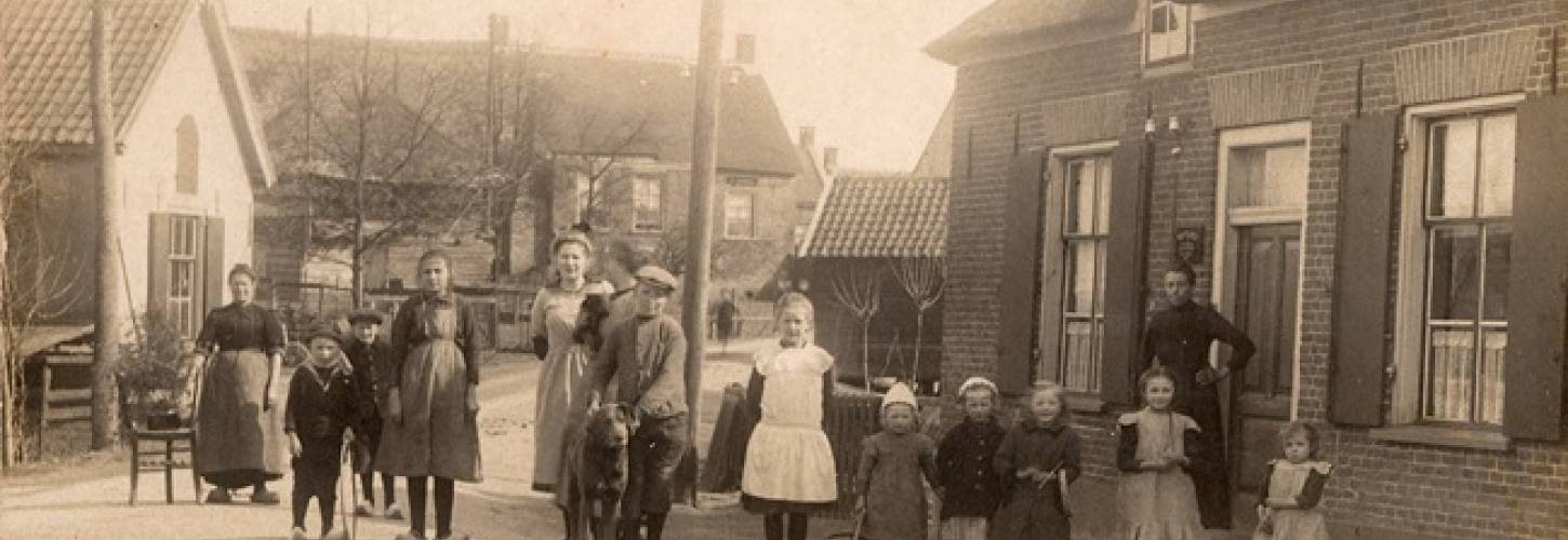 Prentbriefkaart met vrouwen en kinderen die poseren op de R.M. van Gellicumstraat in Rumpt