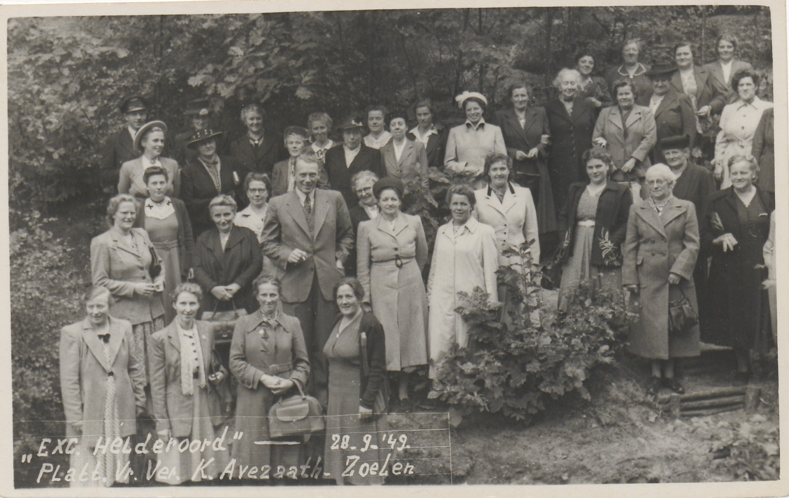 zwart wit foto met een grote groep vrouwen en 2 mannen