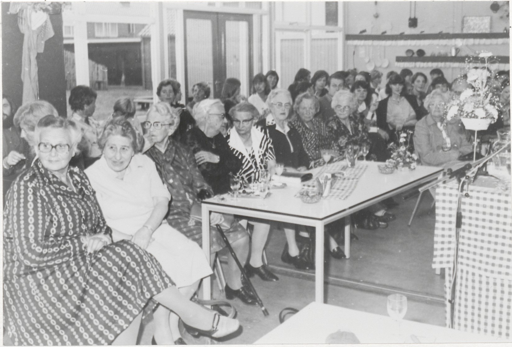 zwart wit foto van vrouwen achter tafels