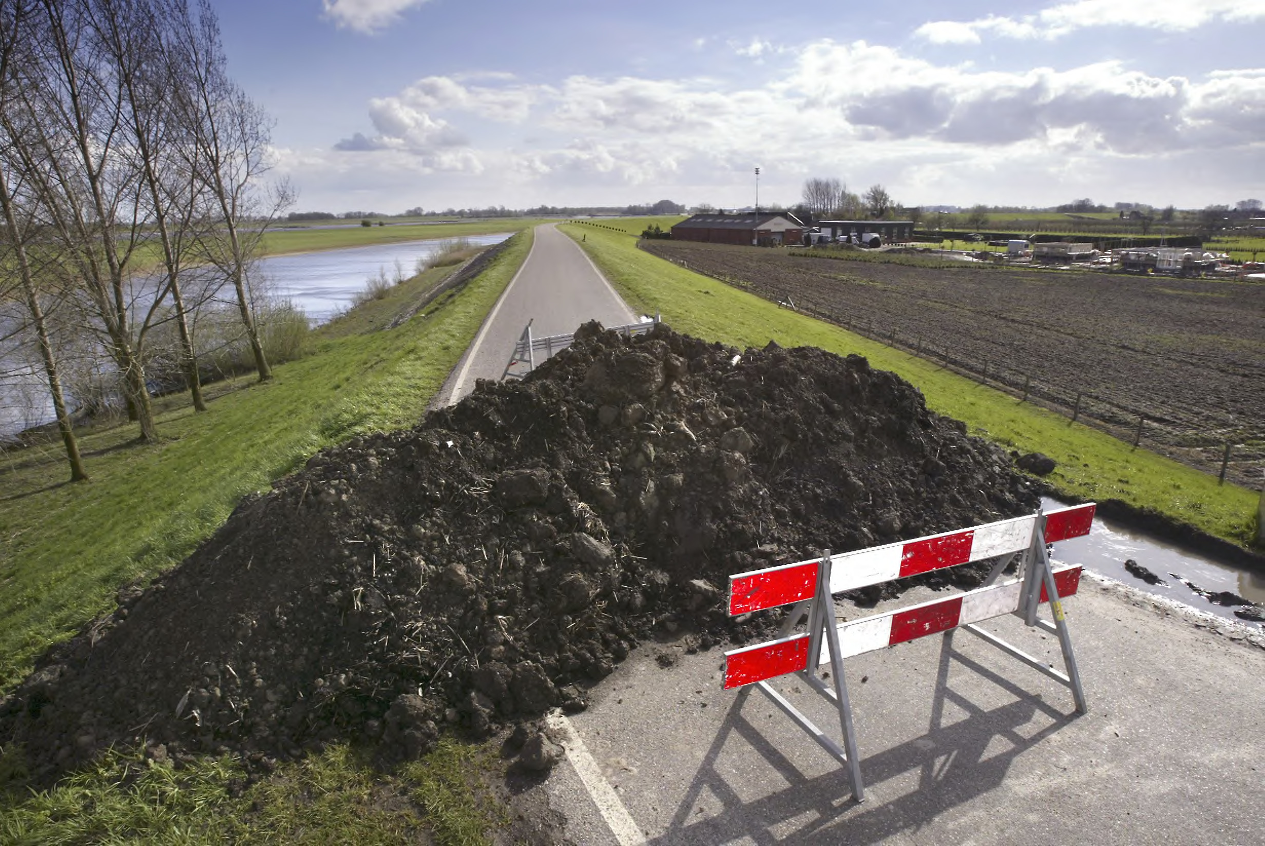 dijk die is afgesloten met een bord en een berg aarde
